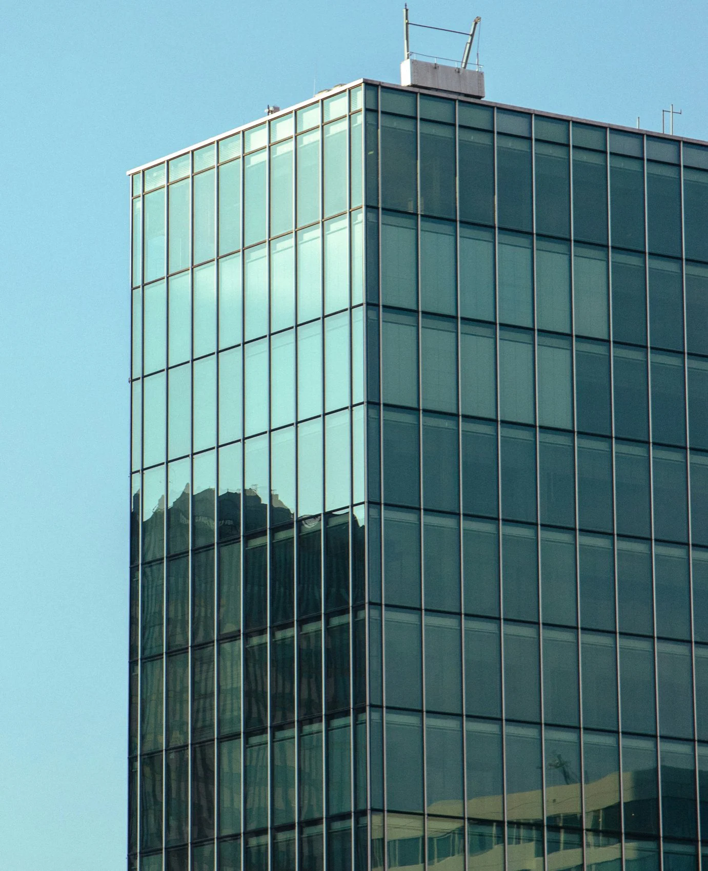 Glazen kantoorgebouw tegen een blauwe lucht